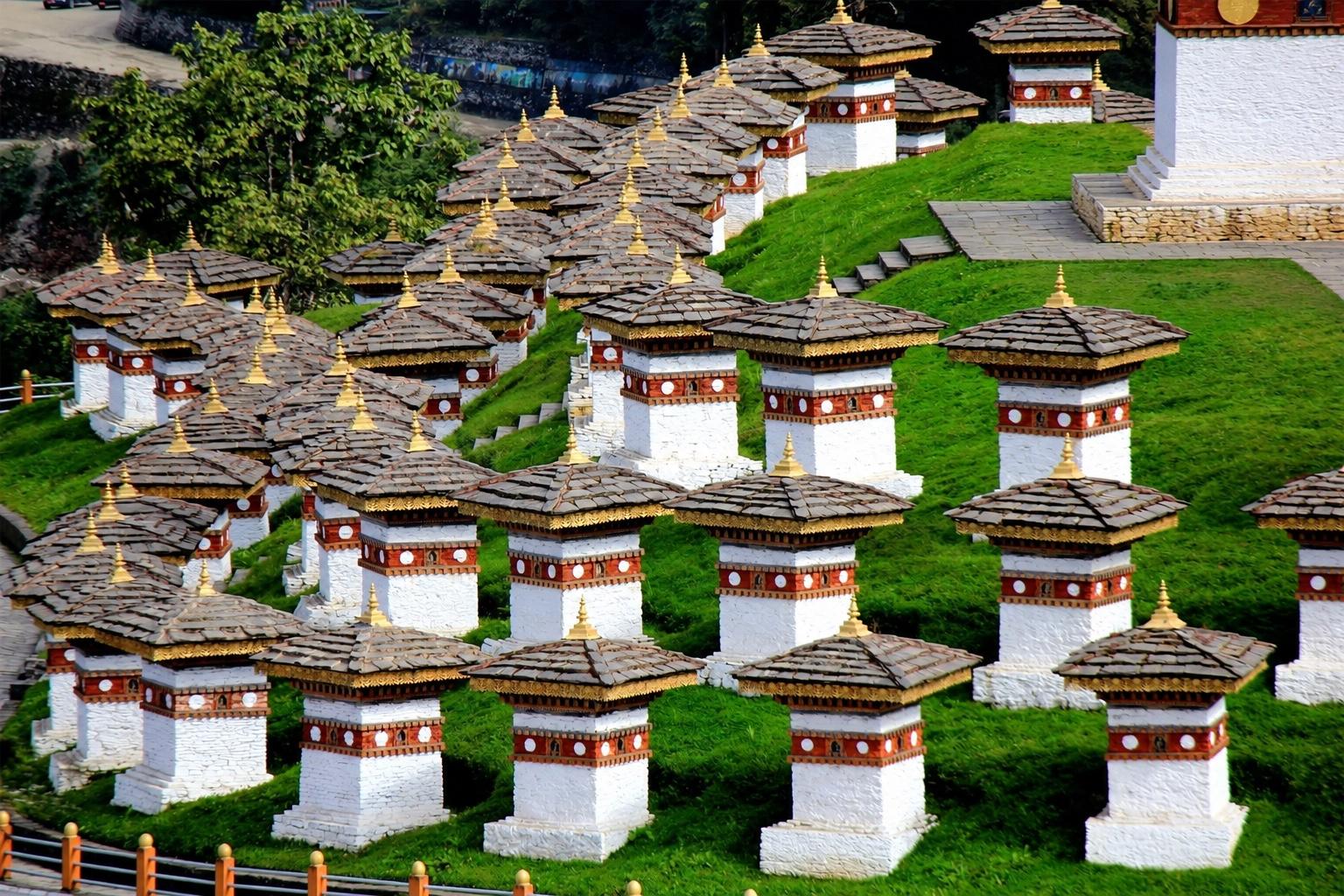 The 108 Druk Wangyal chortens arranged across the green hillside at Dochula Pass