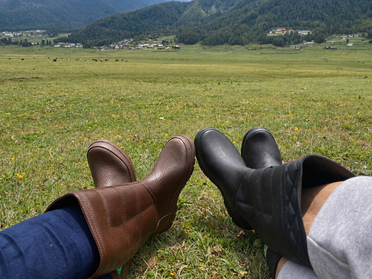 Two travelers resting in the grass above Phobjikha Valley